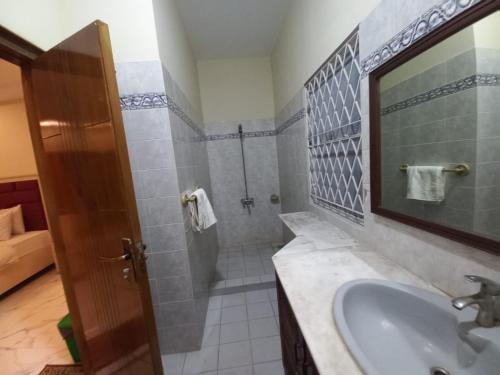 a bathroom with a sink and a shower with a mirror at Dove INN Express II in Lahore