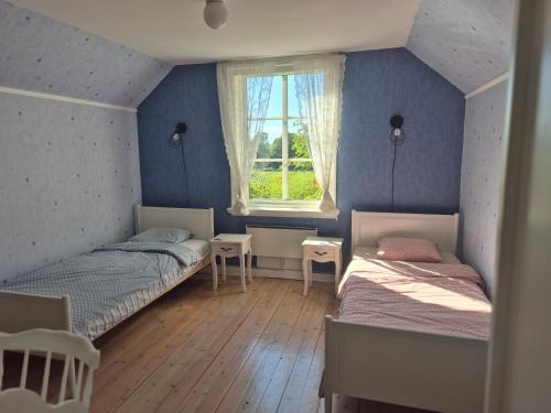 a bedroom with two beds and a window at Vitahästen in Hästveda