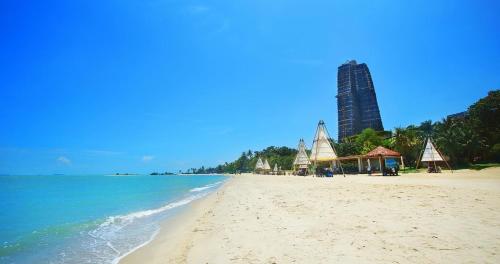 a view of a beach with a tall building in the background at Forest City Eco Stay in Gelang Patah
