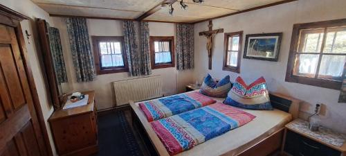 a bedroom with a bed with colorful blankets and pillows at Ferienhäuschen Rahm in Hainzenberg