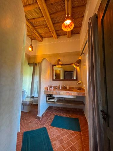 a bathroom with a sink and a toilet and a mirror at Maison d'hôtes de charme Kasbah de Mimi Gorges du Dades in Aït Yous