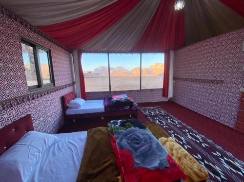 a bedroom with a bed and a large window at Salem Wadi Rum Road in Wadi Rum