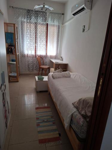 a bedroom with a bed and a desk and a window at stanza a casa marina in Rosolina