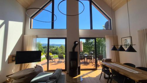 a living room with a large window and a table at Chata Vista in Rožnov pod Radhoštěm