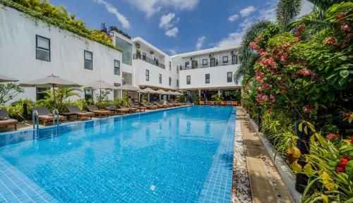 a pool at a hotel with chairs and flowers at Onederz Kampot in Kampot