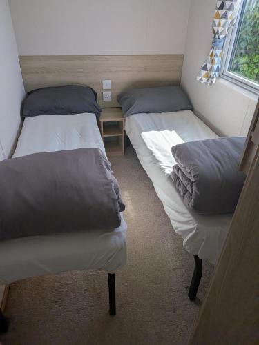 two twin beds in a room with a window at The Link Inn in Allhallows