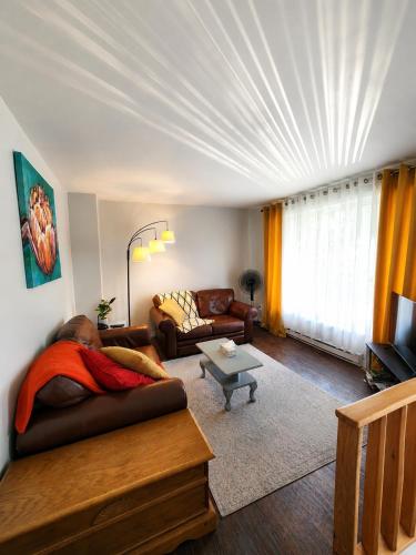 a living room with a couch and a table at Maison St-Raymond Duplex in Matane