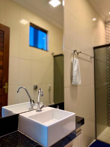 a bathroom with a white sink and a mirror at Apartamento Prates - Próx a BR 040 in Sete Lagoas