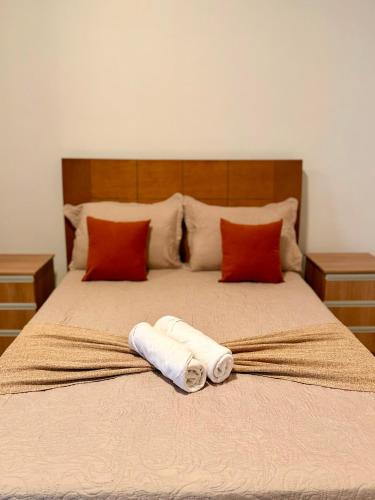 a bed with two rolled towels sitting on it at Apartamento Prates - Próx a BR 040 in Sete Lagoas