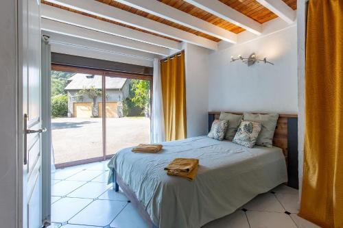 a bedroom with a bed and a large window at Gîte de groupe Le Domaine - 26 personnes au coeur des Pyrénées l Ô Domaine de Geu in Geu