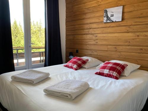 a bed with three pillows on it in a bedroom at Résidence les 3 Sommets in Sarcenas
