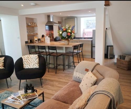 a living room with a couch and a kitchen at Sam's retreat in Hayle