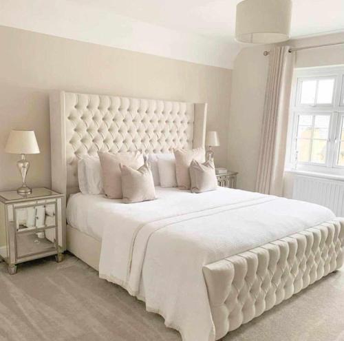 a white bedroom with a large white bed with white pillows at The Comfort Corner in Dundalk