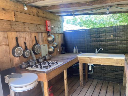 an outdoor kitchen with a stove and a sink at Igloo, Lodge et Tipi confortable in L Honor De Cos