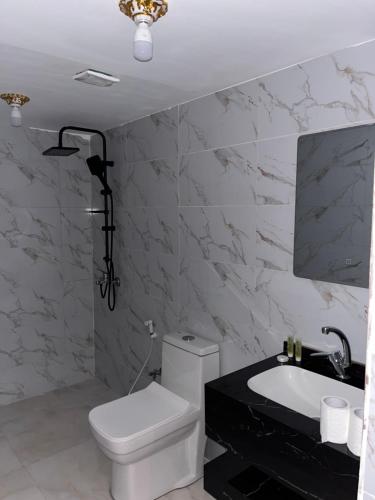 a bathroom with a white toilet and a sink at Maea wade ram in Disah