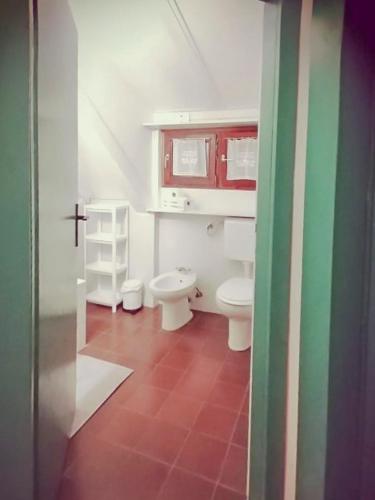 a bathroom with two toilets and a red cabinet at počitniška hiška MEDVEJKE in Slap ob Idrijci