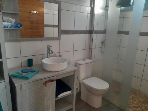 a white bathroom with a sink and a toilet at Kazalou in Terre-de-Bas