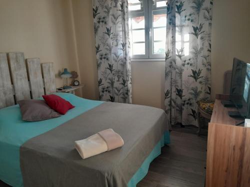 a bedroom with a bed with a towel on it at Kazalou in Terre-de-Bas