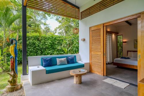 a patio with a blue couch and a table at Villa Lapa 10-15 min walking to the beach in Punta Uva