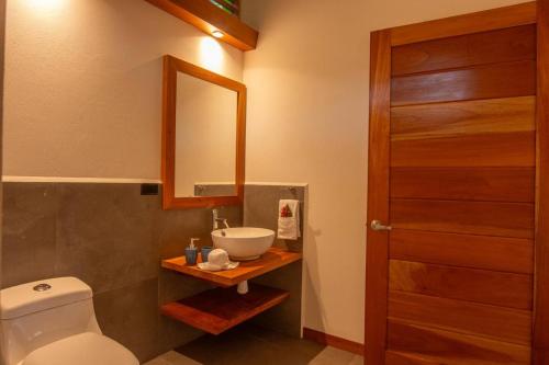 a bathroom with a sink and a toilet and a mirror at Villa Lapa 10-15 min walking to the beach in Punta Uva