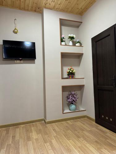 a room with a wall with a tv and a door at Gold Hotel Quba in Quba