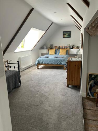 a attic bedroom with a bed and a window at Blindwell House in Nether Stowey