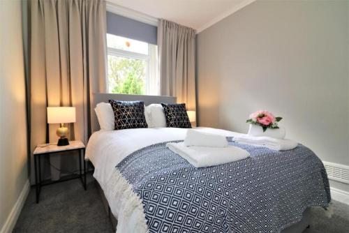 a bedroom with a large bed with pillows and a window at Macintosh lower in Bellshill