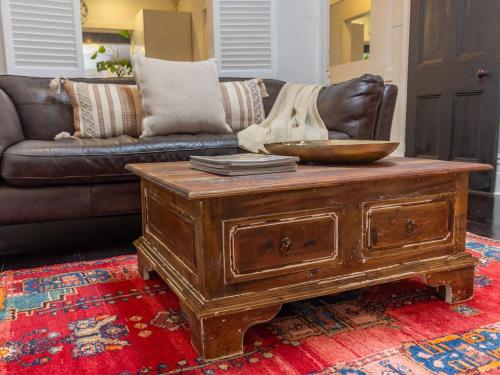 a living room with a wooden coffee table and a couch at Secluded Hackney Cottage Near Botanic Gardens with Free Parking - Koala Stay in Adelaide