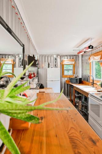a large kitchen with a wooden table in it at Maison Conteneur d'Expedition in Amos