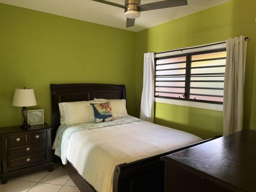 a green bedroom with a bed and a window at Charming 1BR Villa Steps from Red Hook Hotspots in Nazareth