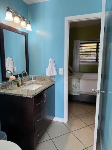 a bathroom with a sink and a mirror and a bed at Charming 1BR Villa Steps from Red Hook Hotspots in Nazareth