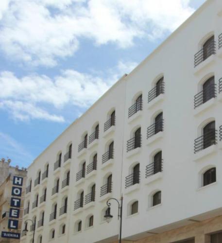 a white building with windows and a cloudy sky at Hotel El Djenina in Tangier