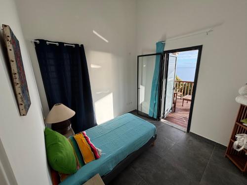a room with a bed and a sliding glass door at Villa Papang in Saint-Paul