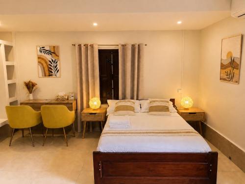 a bedroom with a bed and a table and chairs at Studio confort Passamainty in Mamoudzou