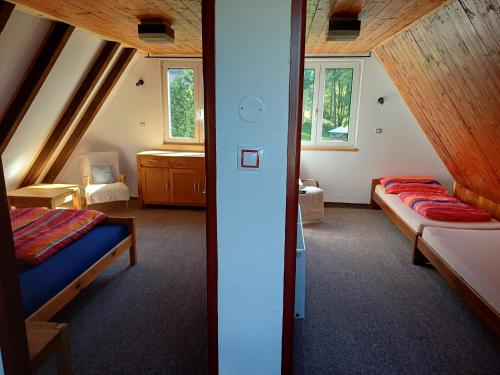 a attic room with two beds and a sink at Chaloupka na vršku in Loučná pod Klínovcem