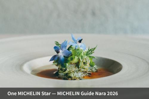 a small dish with blue flowers on a white plate at VILLA COMMUNICO,Nara in Nara