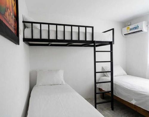 a bedroom with two bunk beds and a ladder at Apartaestudio amoblado Aeropuerto PIMSA bombona in Malambo