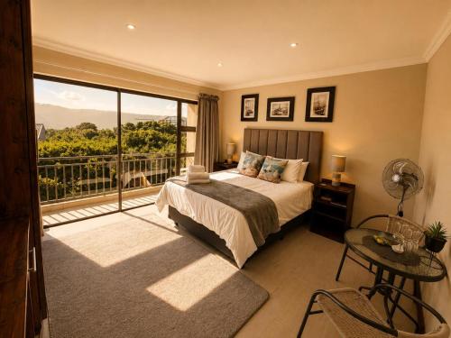 a bedroom with a bed and a large window at On Appointment at the Sea in Wilderness