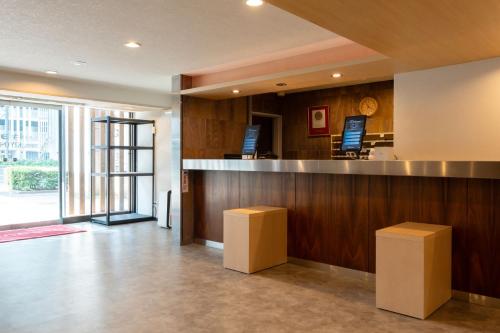 a lobby with a bar with stools in a building at Hotel Kiyoshi Nagoya in Nagoya