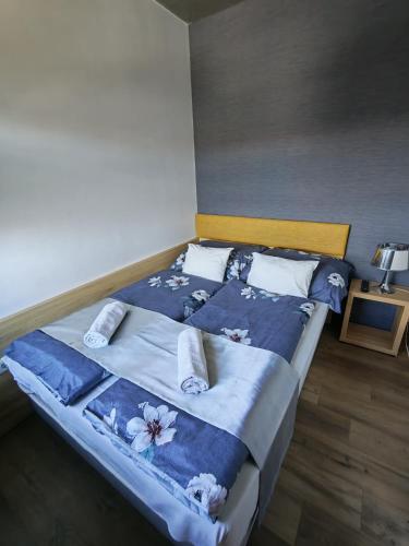 a bedroom with a large bed with blue sheets and pillows at Jáde Residence Apartman in Sárvár