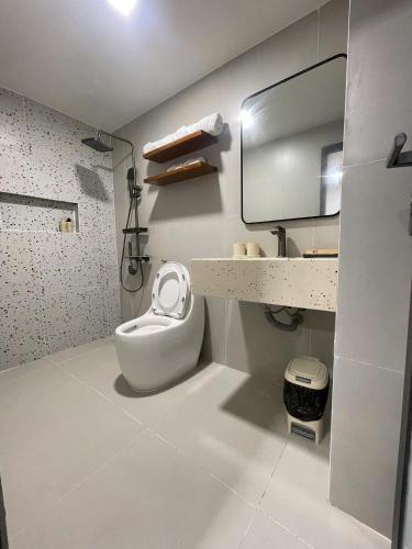 a white bathroom with a toilet and a sink at Doge Hotel in Quảng Ngãi