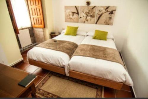 a bedroom with a large bed with green pillows at Casa rural La rectoral in Areas