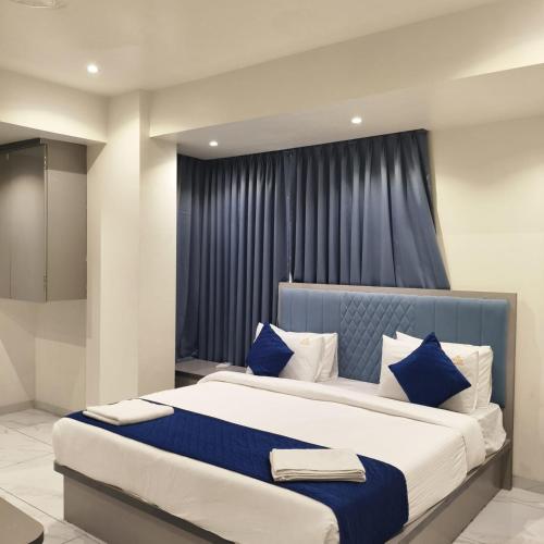a bedroom with a large bed with blue and white pillows at Marina Executive Rooms in Navi Mumbai