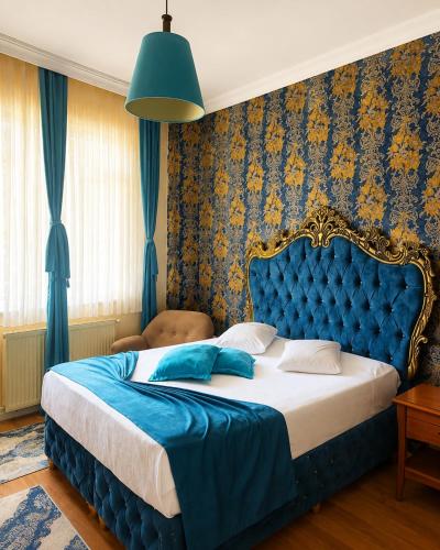a bedroom with a large bed with a blue headboard at Green Moringa Termal Hotel in Termal