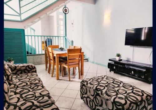 a dining room with a table and chairs and a television at Blue Haven in Grand-Baie