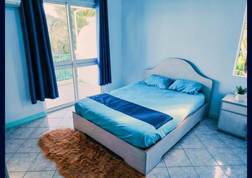 a bed in a room with a window at Blue Haven in Grand-Baie