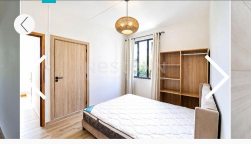 a small room with a bed and a door at Maranatha Villa in La Gaulette