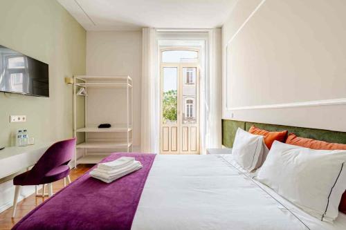 a bedroom with a large white bed with a purple blanket at Vestígios de Charme - Figueira Suits in Figueira da Foz