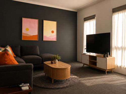 a living room with a couch and a flat screen tv at Layover Lounge in Perth