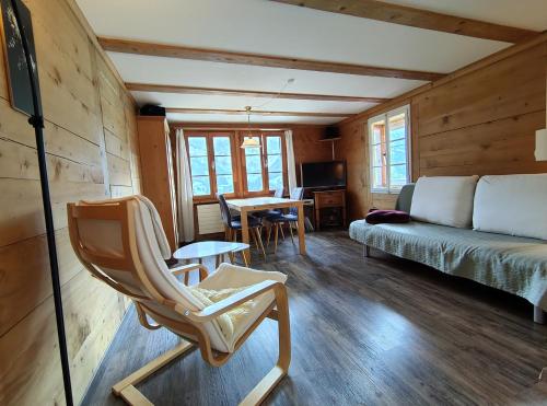 a room with a bed and a chair and a table at Chalet Sonnenheim mit atemberaubender Aussicht in Adelboden